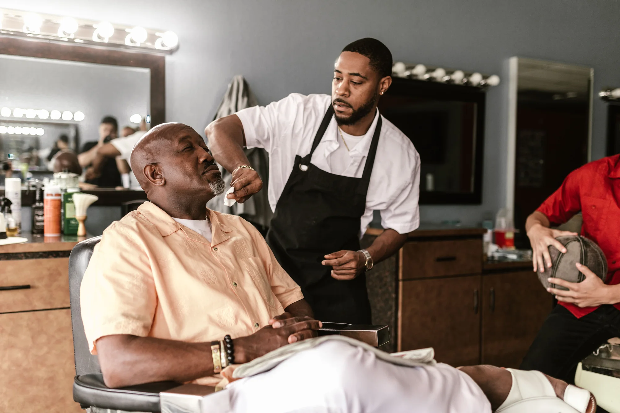 Demonstration image of a barber attending a client in a barbershop.