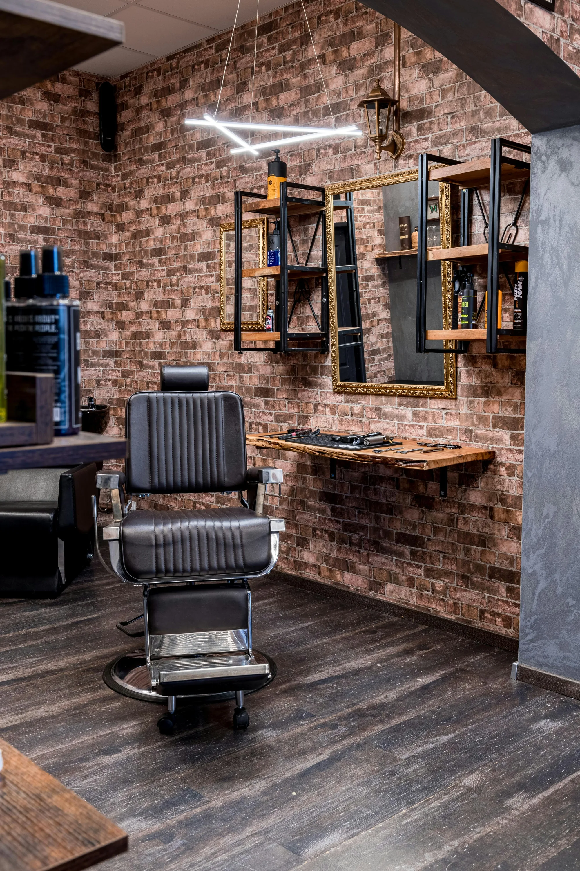 Barber chair and workstation in an industrial-style barbershop interior.